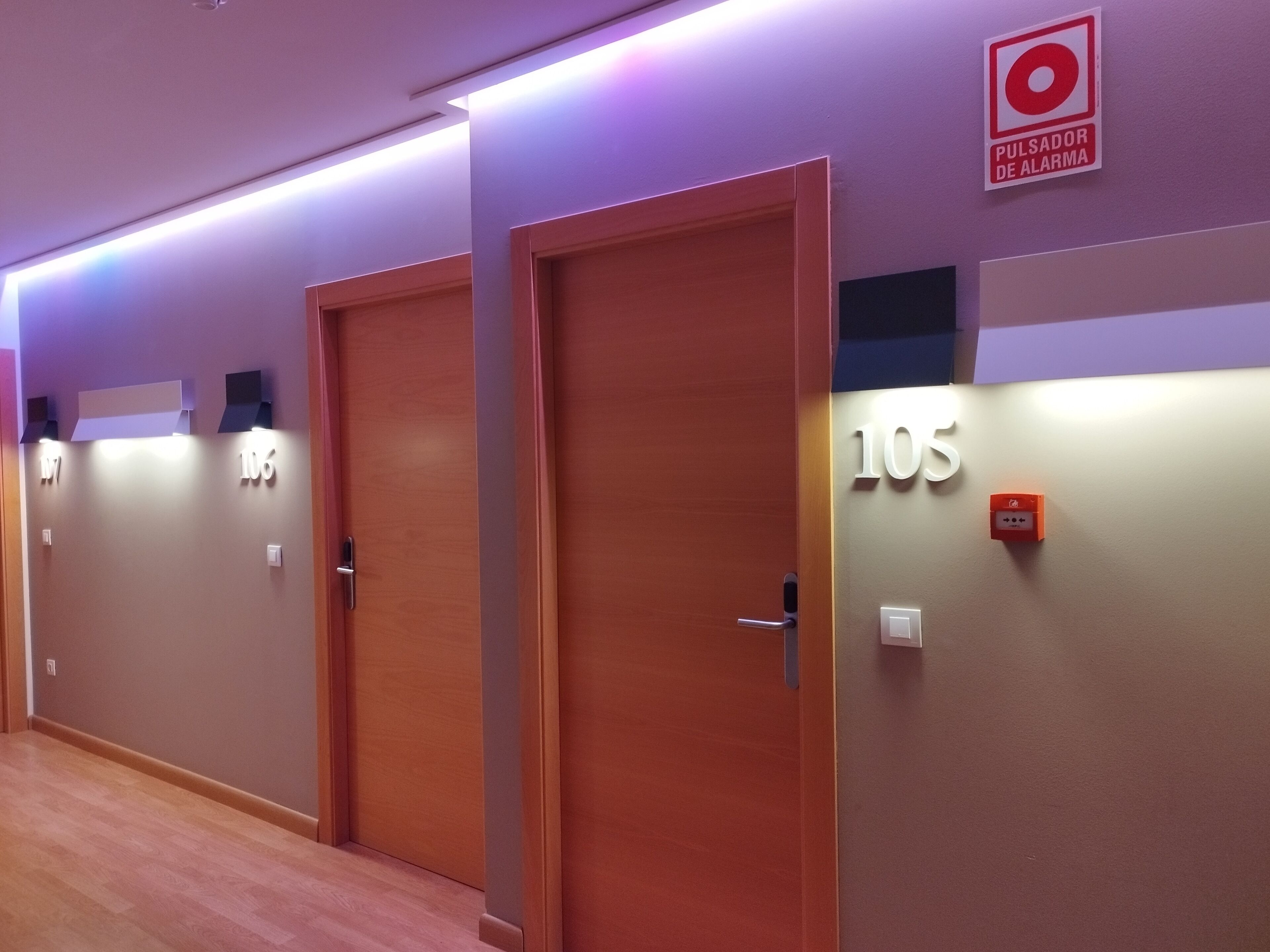 A hallway with doors numbered 105, 106, and 107, each with a small sign above the door.