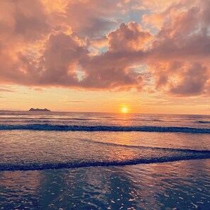 A sunset over the ocean with waves and a distant island. - Casa Arenas, steps away from the ocean! (Provincia de Puntarenas)