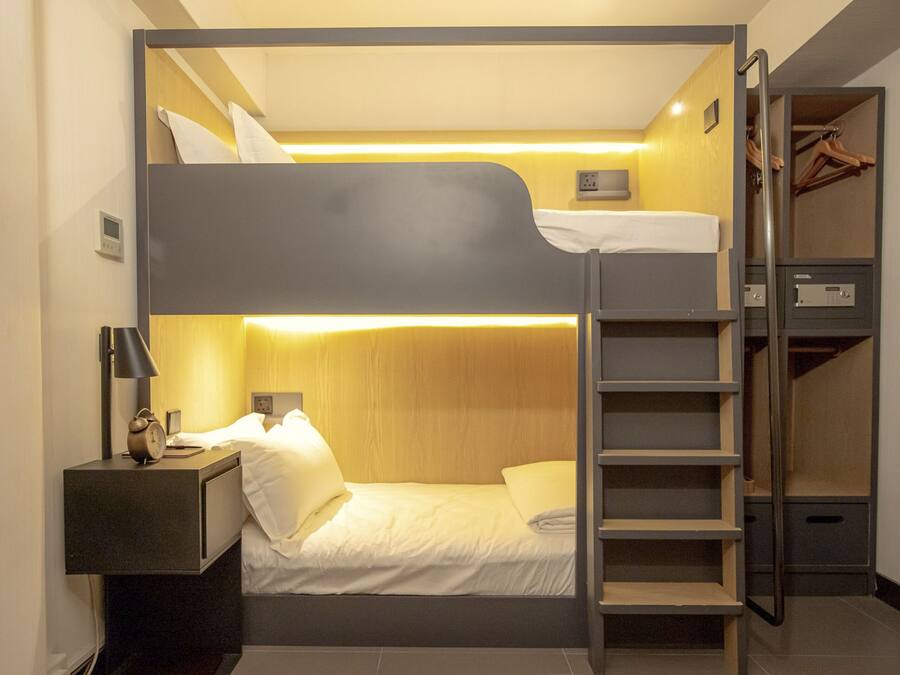 Habitación con literas, escritorio, lámpara y armario.