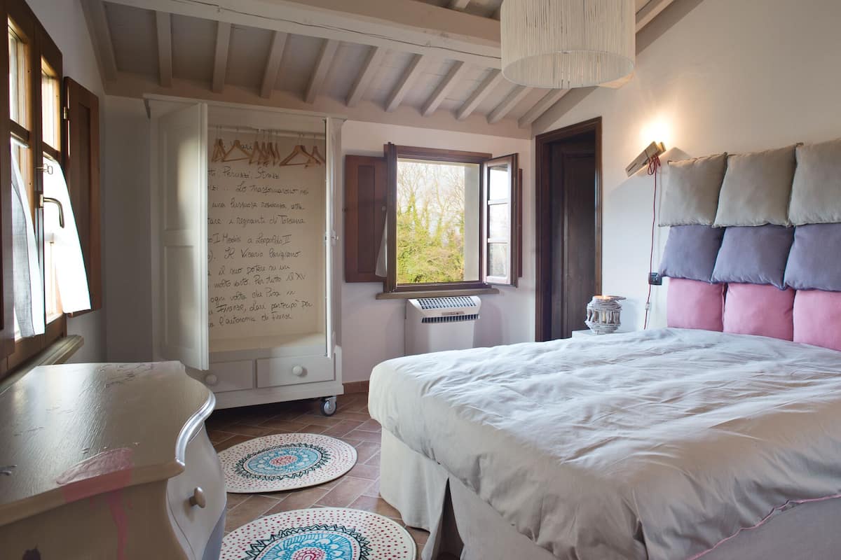 A bedroom with a bed, a desk, and a whiteboard.