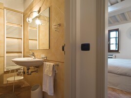 Un baño con lavamanos, toallero y espejo.