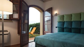 A bedroom with a bed, a chair, and a window. - San Ruffino Apartments (Casciana Terme Lari)