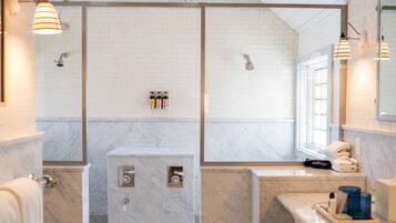 Une salle de bain moderne dotée d’une grande baignoire, d’une douche séparée et d’un meuble-lavabo avec un miroir.
