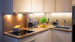 Una cocina moderna con electrodomésticos de acero inoxidable, encimera de madera y un lavabo.