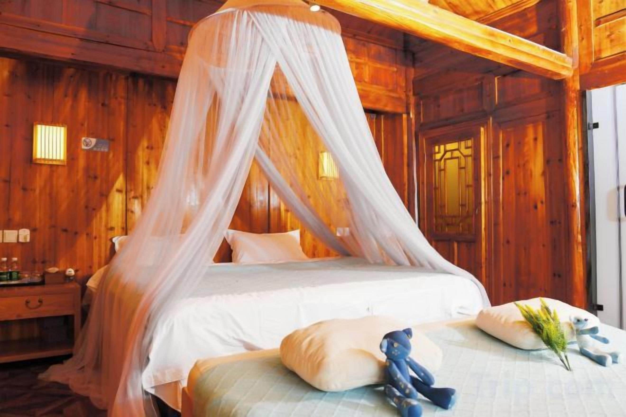 Una camera in stile baita con un letto a baldacchino, un comodino e una porta in legno.