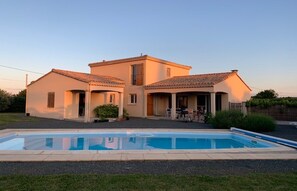 Une maison à deux étages avec une piscine à l’avant.