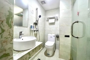 A bathroom with a white sink, toilet, and shower.