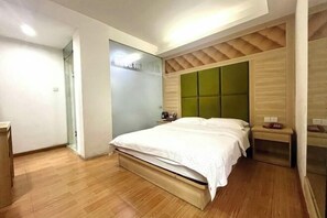 Un dormitori amb llit, una tauleta de nit, un mirall i un armari.
