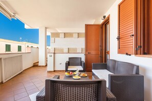 Enjoy a peaceful retreat on your balcony with a wicker chair, small table, and beautiful views.