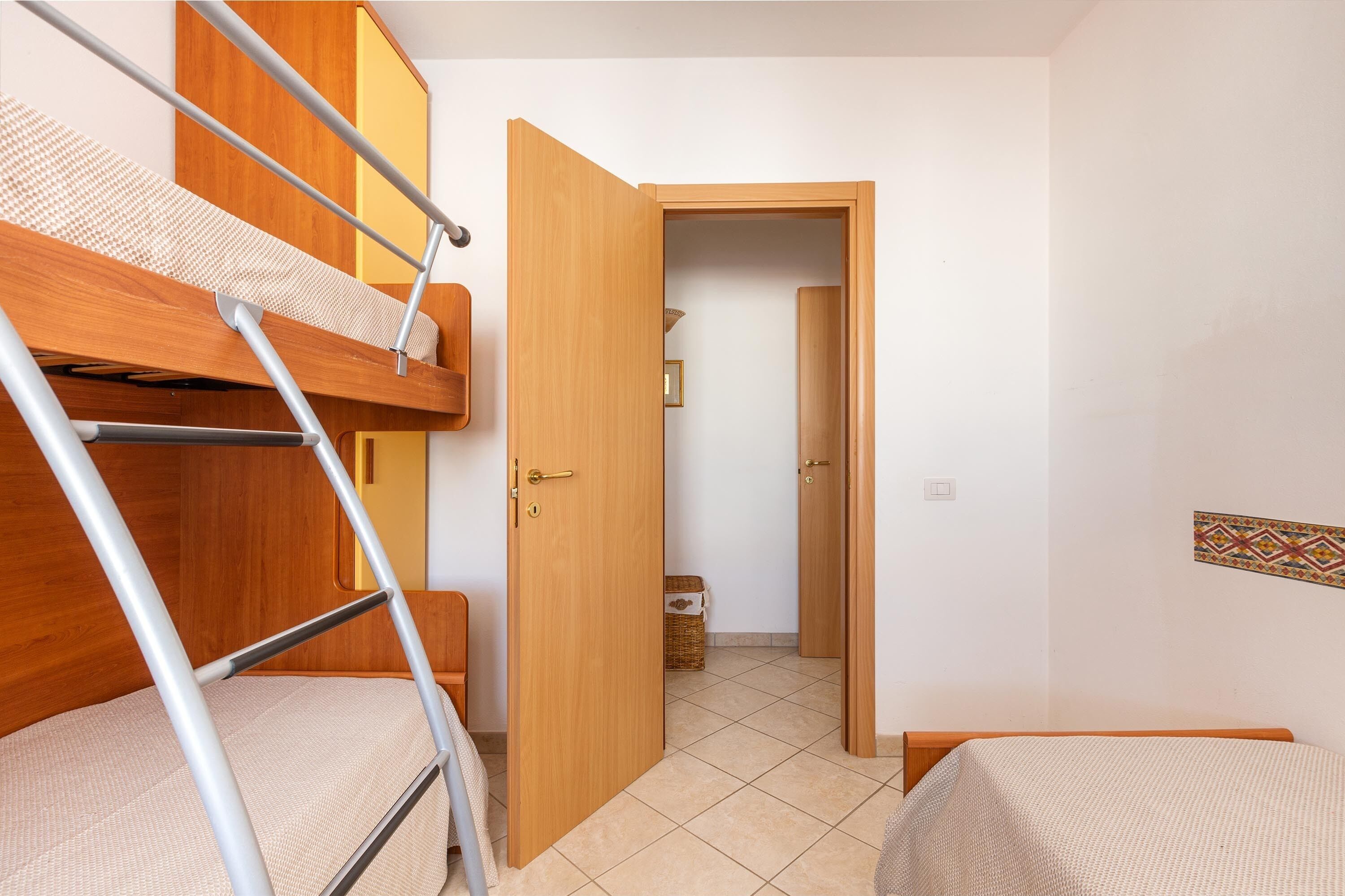 Ein Zimmer mit Etagenbetten, einer Holztür und einem kleinen Flur.
