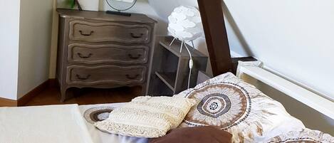Un dormitorio con cama, cómoda, espejo y un adorno en la pared.