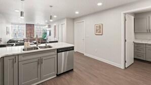 A modern kitchen with a large island, stainless steel appliances, and a view of the city through large windows.