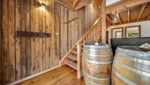 A rustic interior with wooden walls, a wooden staircase, and two large barrels. - Aarlaur 2 - Charming 2BR Rustic Home l Bath l Fire Pit l WiFi Air-Con (Jindabyne)