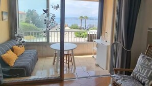 Un balcon avec vue sur la mer, un canapé, une table et une chaise.