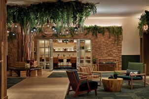 A cozy interior with a wooden reception desk, a dining area, and comfortable seating.