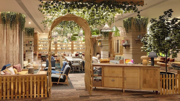 A cozy, plant-filled lounge area with wooden furniture and a bar. - Treehouse Hotel Manchester (Manchester)