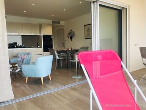 Ein modernes Wohnzimmer mit einem Esstisch, Stühlen und einem leuchtend roten Sessel.