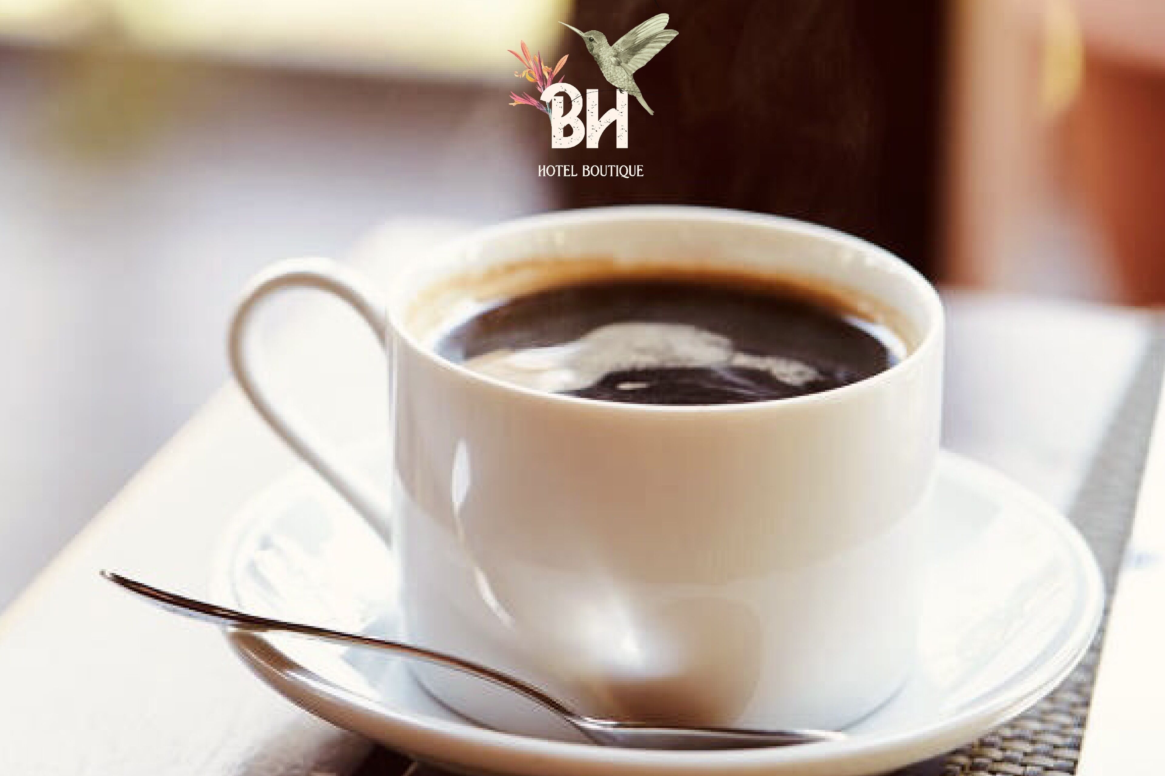 Une tasse de café blanche, posée sur une soucoupe avec une cuillère, sur une table.