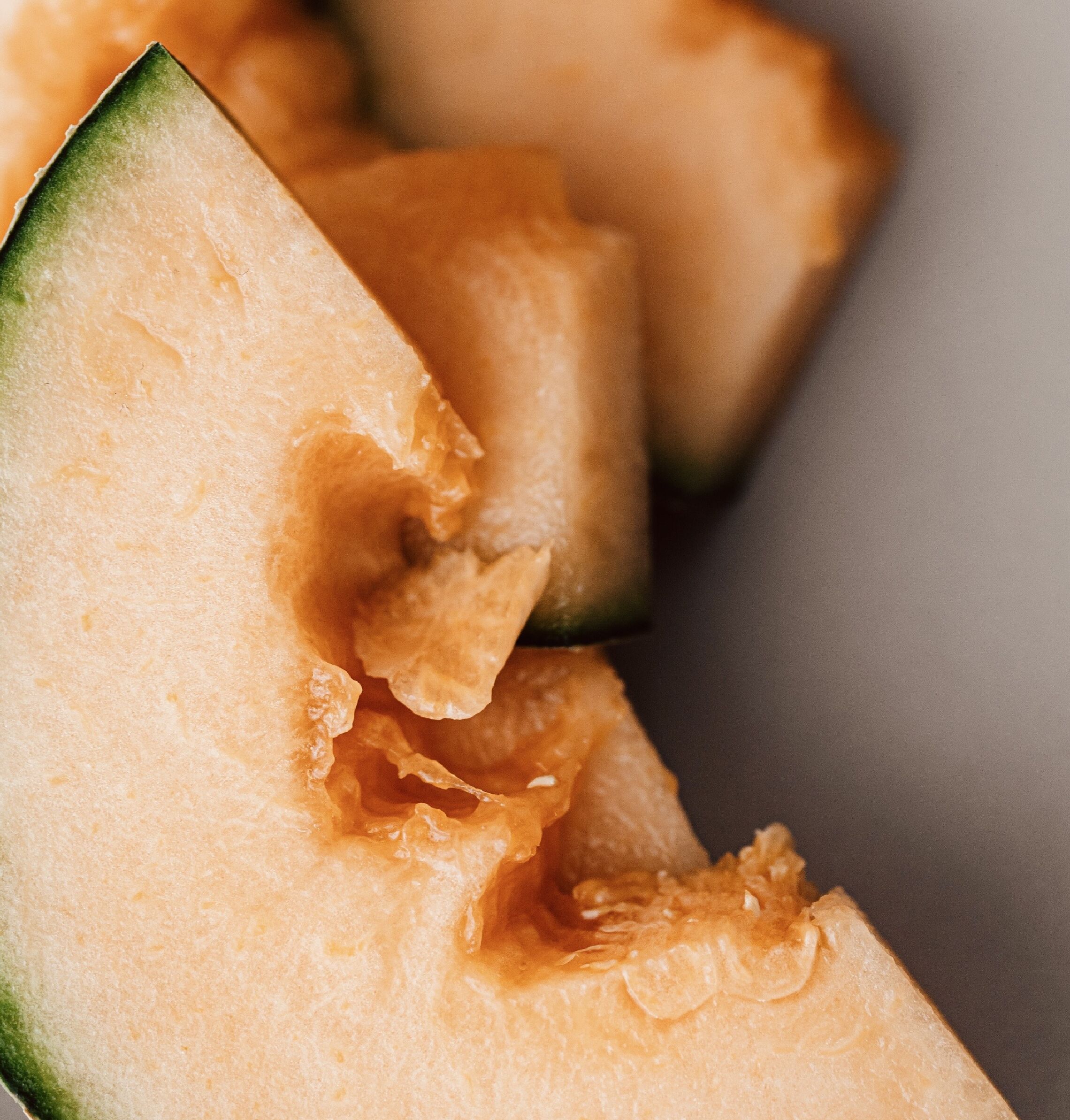 Primer plano de un melón cantalupo cortado por la mitad, mostrando su interior jugoso.