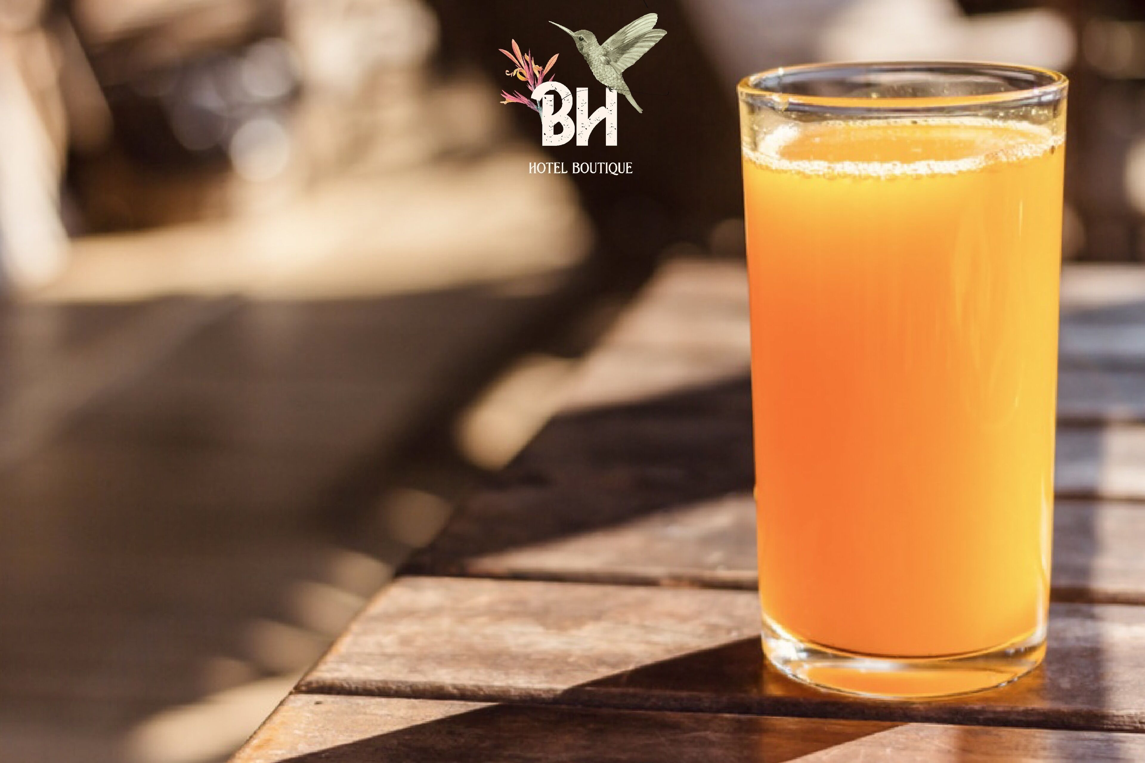 Un vaso de jugo de naranja sobre una mesa de madera con un fondo desenfocado.