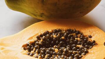 En papaya halveret, med frøene synlige.