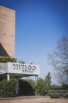 The exterior of the Mitico Hotel with a clear sky.