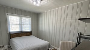 A bedroom with a bed, a chair, a desk, a window, and a ceiling light. - Location. Location. Location. Only 15 minute walk to Mackey Arena. (West Lafayette)