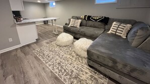 A modern living room with a grey sofa, a white coffee table, and a patterned rug. - Location. Location. Location. Only 15 minute walk to Mackey Arena. (West Lafayette)