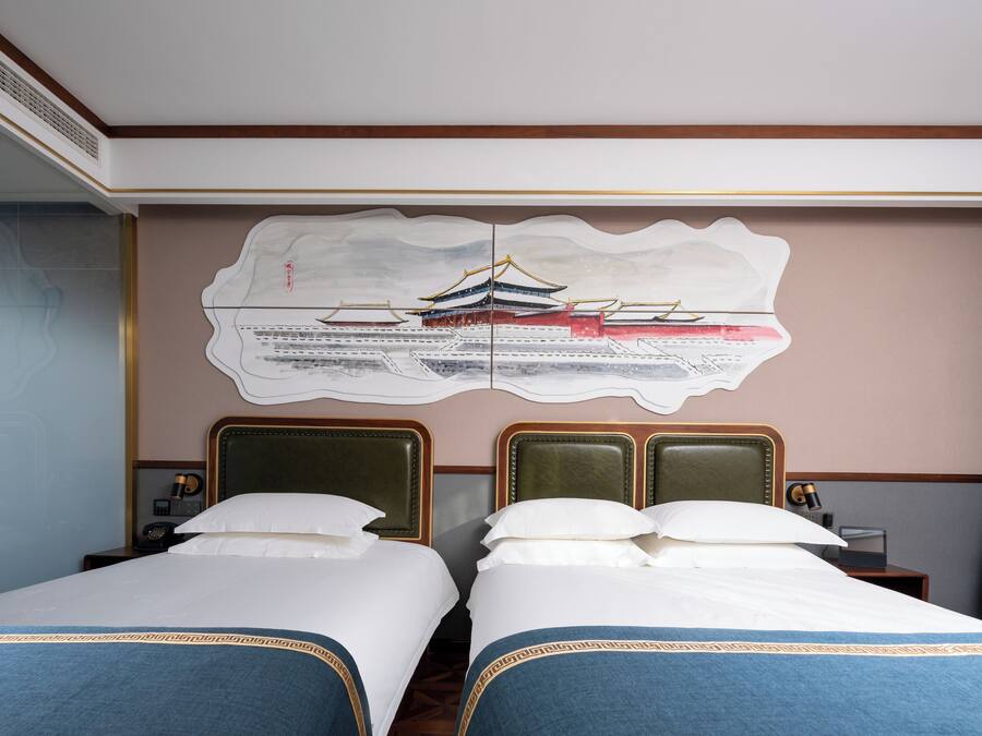 A hotel room with two beds, a large wall mural, and a wooden ceiling.