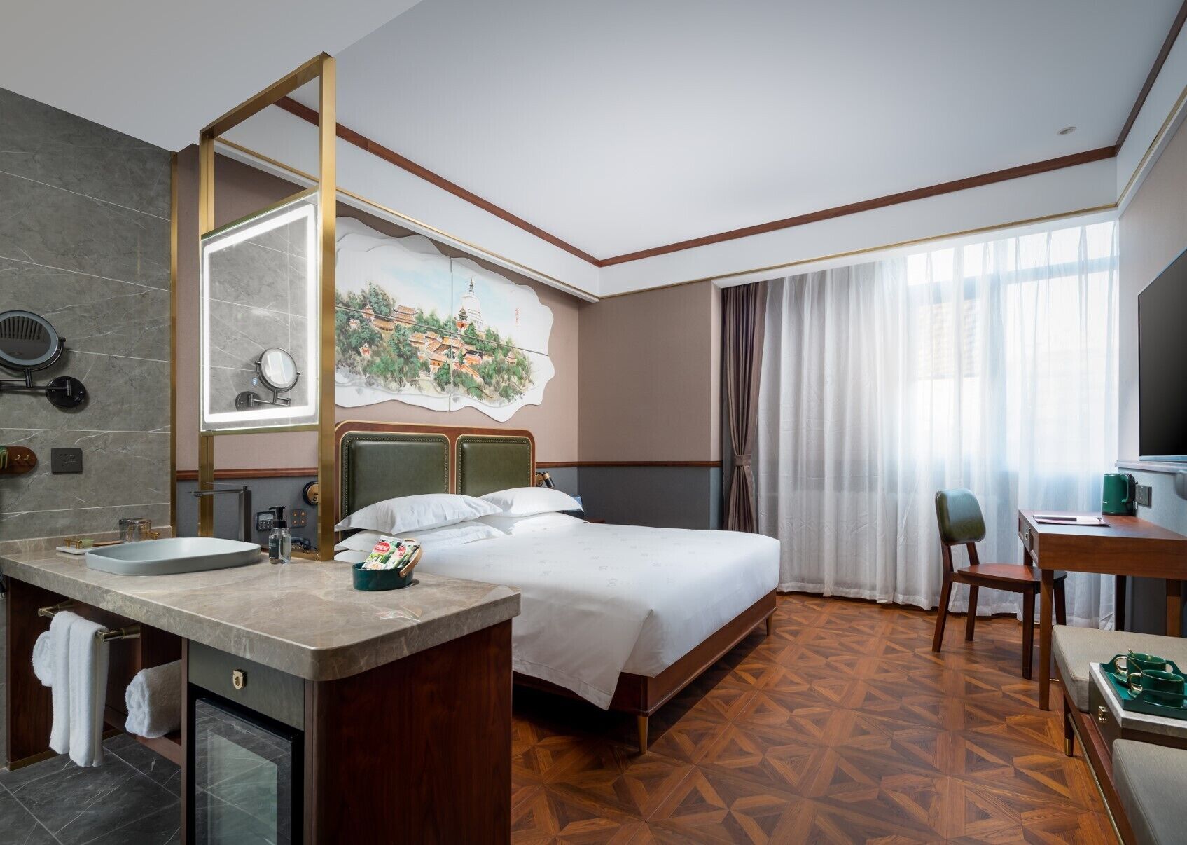 A hotel room with a bed, a desk, a chair, a bathroom with a sink and mirror, and a large window with curtains.