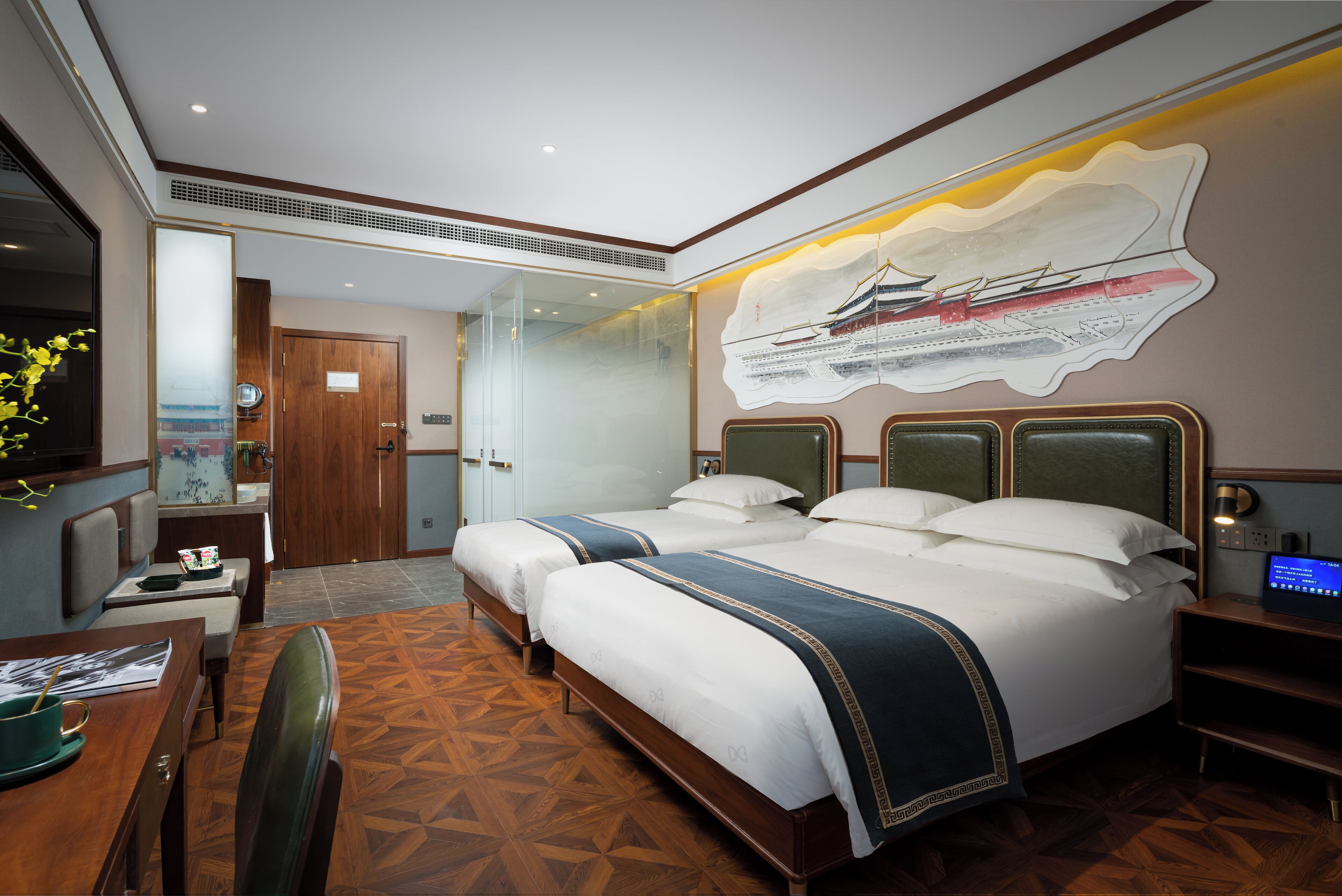 A hotel room with a large bed, a desk with a chair, a TV, and a wall-mounted artwork.