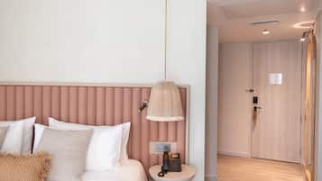 A hotel room with a bed, bedside lamp, and a phone on a small table.