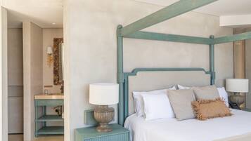 Un dormitorio con cama con dosel, una mesita de noche con lámpara, un tocador con espejo y una estantería en la pared.