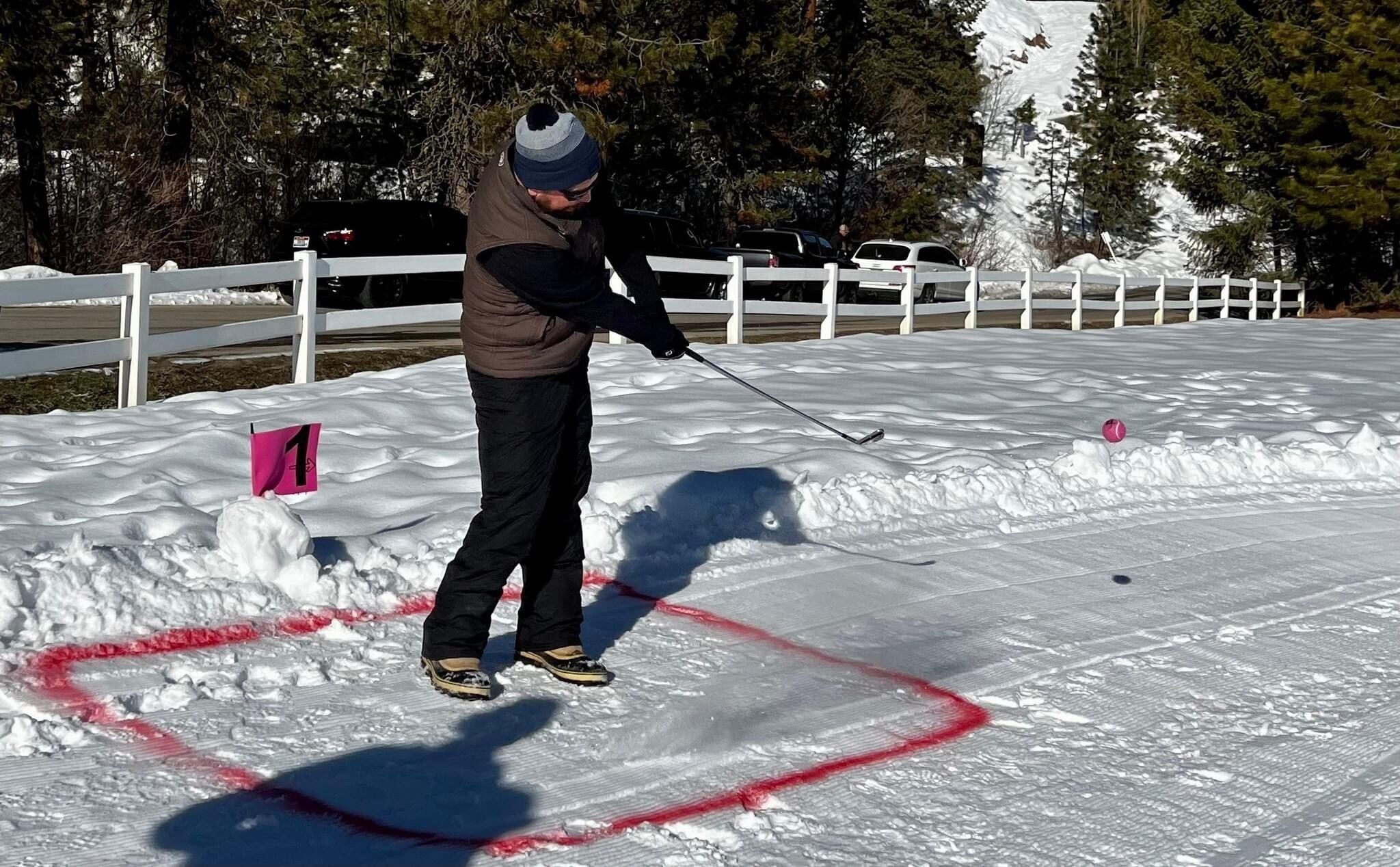 Una persona esquiando en una pendiente cubierta de nieve, con una valla blanca al fondo.