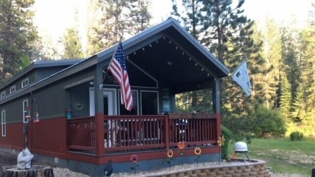 Eine Hütte mit Veranda, einer amerikanischen Flagge und einer Flagge mit Vogelwappen.
