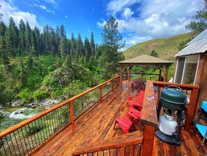 A wooden deck with a river view, a gazebo, and outdoor seating. - Awesome Views of the Southfork Payette, Hot Tub and Room to Roam (Garden Valley)