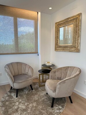 A room with two armchairs, a round table, and a large window with a view. - To complete (Cala Blanca)