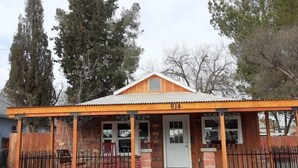 A small, single-story building with a wooden facade, a covered porch, and a number "914" displayed above the entrance.