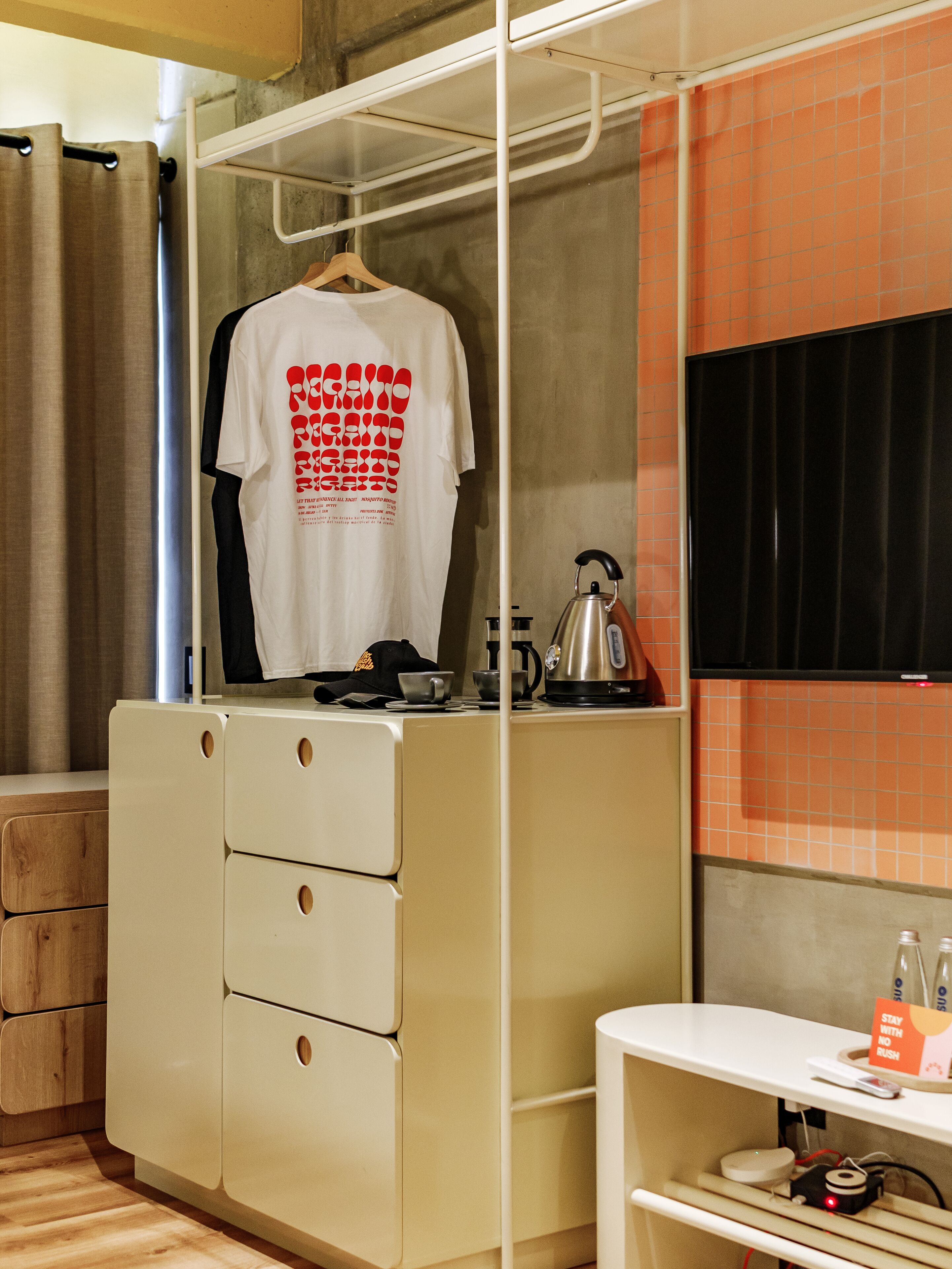 Une chambre d’hôtel de taille réduite, dotée d’un placard, d’une petite kitchenette et d’un lit.
