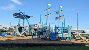 A playground with slides, climbing structures, and a shaded area. - Surf City Cozy Home · Pets Welcome · Monthly OK (Holly Ridge)