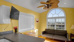 A kitchen with a gray countertop, a ceiling fan, and a window with blinds. - Surf City Cozy Home · Pets Welcome · Monthly OK (Holly Ridge)