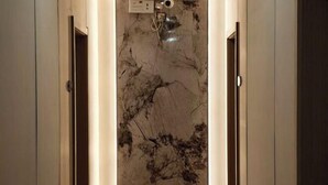 A hallway with marble walls and a door at the end. - Hongtu Business Hotel (Congjiang)