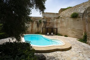Una piscina al aire libre de temporada, tumbonas