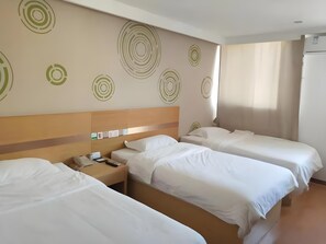 A hotel room with three single beds, a wooden headboard, a wall with circular patterns, a bedside table with a phone, and a window with curtains. - Green Tree Inn Yantai Zhifu Donglu Branch (Yantai)