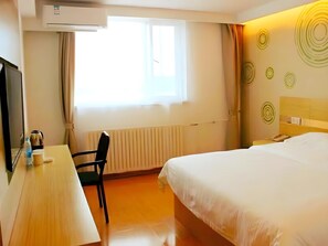 A hotel room with a bed, a desk, a chair, a television, and a window with curtains. - Green Tree Inn Yantai Zhifu Donglu Branch (Yantai)