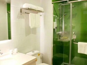 A bathroom with a glass-enclosed shower, a white sink with toiletries, and a towel rack. - Green Tree Inn Yantai Zhifu Donglu Branch (Yantai)