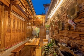 A narrow corridor with wooden walls, a bench, and decorative items. - Yinhe Boutique Inn (Lijiang)