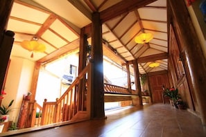 A wooden interior with a high ceiling, a staircase, and hanging lanterns. - Yinhe Boutique Inn (Lijiang)