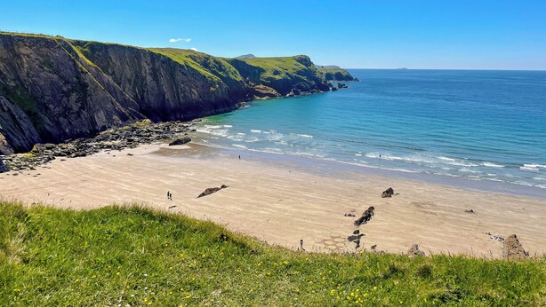 A coastal landscape with a sandy beach, grassy cliffs, and a clear blue sky. - 3 bedroom accommodation in Porthgain, near St David&rsquo;s (Porthgain, near St David&rsquo;s)