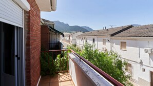 Ein Wohngarten mit Blick auf benachbarte Gebäude und einen Berg im Hintergrund.